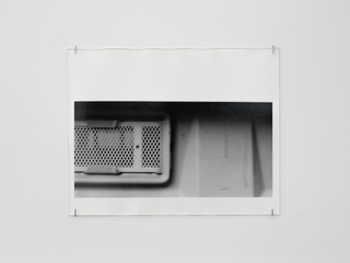 Dixi ventilation screen, Berlin, a, 2022, silver gelatin print, glass, pins, 30.35 x 40.7 cm